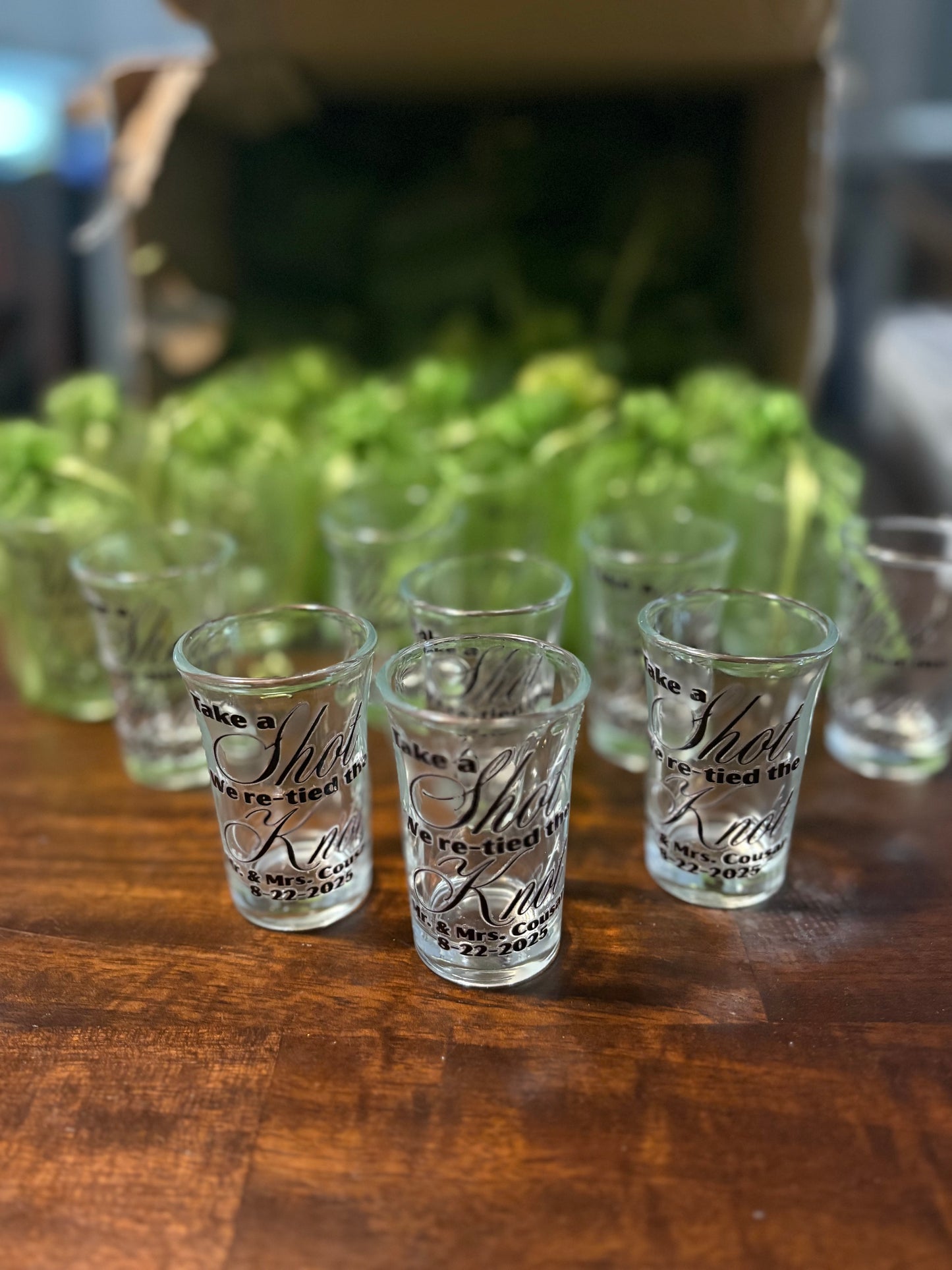 Set of shot glasses with engraved text on a wooden surface