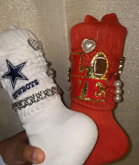 A pair of decorative socks, one in white and the other in red, each with a different design and embellishments.
